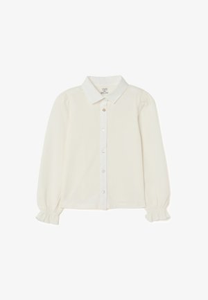 Blusa de botones color crema con mangas largas, hombros abullonados, cuello clásico y puños con volantes; tejido suave con un ligero brillo.