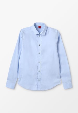 Camisa azul claro de manga larga con botones y cuello puntiagudo, extendida sobre un fondo blanco.