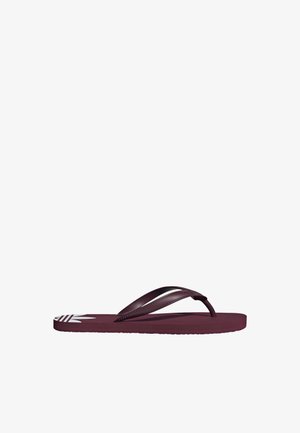 Une seule sandale tongs violette foncée avec un détail de logo blanc sur la semelle, affichée sur un fond blanc uni.