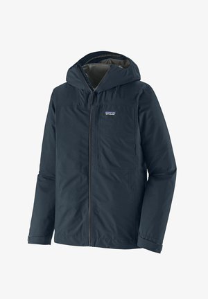 Marine vanntett jakke med hette, frontglidelås og to brystlommer. Glatt tekstur med et enkelt design og merkevarelogo på venstre side.