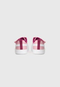 Baskets roses avec une finition texturée, semelles blanches et accents arrière magenta contrastants. Dotées d'une sangle et de surfaces lisses.