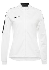 Weiße Nike-Jacke mit vollem Reißverschluss, hohem Kragen und schwarzen Akzenten auf den Schultern. Glatte Textur und körpernahe Passform, geeignet für den Sport.