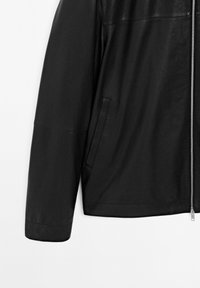 Black leather jacket cropped at shoulder to waist, featuring a vertical side pocket and silver front zipper on a white background.