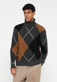 Σκούρο γκρι και καφέ πουλόβερ με ψηλό λαιμό σε σχέδιο άργυλ, με φάσες στις μανσέτες και στο λαιμό, διαθέτοντας αντίθετες λευκές ραφές.