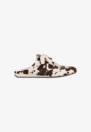 Chaussure slip-on en cuir de vache, avec un motif tacheté marron et crème, présentant un design à lacets et une semelle en caoutchouc texturé pour une meilleure adhérence.