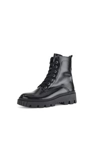 Black ankle boots made of glossy leather, featuring a thick rubber sole, round toe, and lace-up design with metal eyelets.