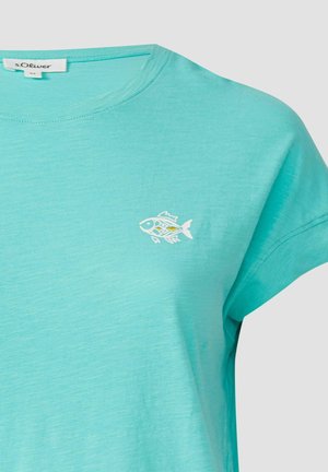 Türkises T-Shirt mit kurzen Ärmeln aus weichem Stoff, das ein kleines weißes Fischmotiv auf der linken Brustseite zeigt.