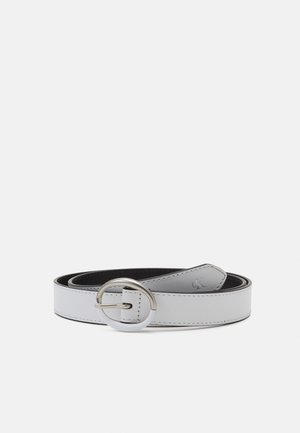 Ceinture en cuir blanc enroulée avec une boucle métallique ronde argentée et des coutures visibles le long des bords sur fond clair.