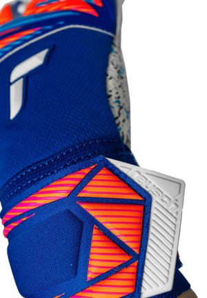 Gros plan sur un gant de gardien bleu et orange avec une prise texturée et des motifs géométriques sur la sangle du poignet.