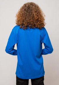 Blue long-sleeve t-shirt made of cotton with a relaxed fit, featuring a crew neckline and visible seams on the back.