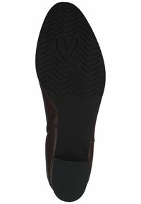 Zapato de cuero marrón con una suela de goma negra texturizada que presenta un patrón ondulado y un logo de corazón. Parte superior suave con un detalle de costura mínimo.