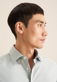 Lichtblauw button-down shirt met een gestructureerde stof en een gemusterde kraag. Het heeft een klassieke kraag en een afgeronde zoom, met een slank model.