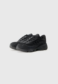 Sorte atletiske sneakers med mesh- og syntetiske materialer, teksturerede overflader og en kraftig såledesign med snørebånd for sikker pasform.