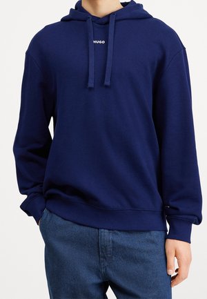Marineblauwe hoodie van een zachte katoenmix, met een voorzak in kangoeroestijl, trekkoordjes en een wit logo op de borst.