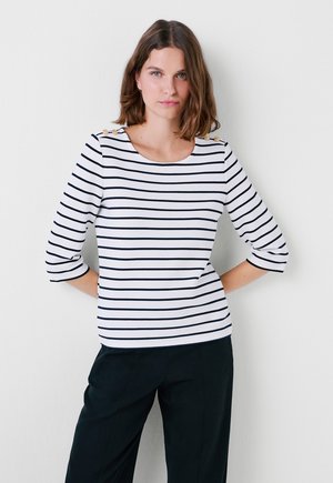 Top a strisce bianche con righe orizzontali navy, maniche a tre quarti, scollatura rotonda e bottoni decorativi sulle spalle.