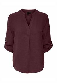 Blusa bordeaux con scollo a V, maniche a tre quarti arrotolate e vestibilità ampia. Tessuto textured con un leggero lucido. Senza motivi o accessori visibili.