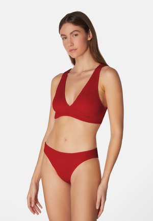 Rotes Bikini-Set aus strukturiertem Material, das ein top mit tiefem V-Ausschnitt und passende tief geschnittene Bottoms mit minimaler Bedeckung beinhaltet.