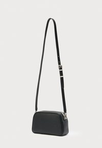 Μαύρο δερμάτινο τσαντάκι χιαστί με λείο υλικό, στρογγυλεμένο σχήμα, κλείσιμο με φερμουάρ και ρυθμιζόμενο λουράκι με μεταλλική πόρπη.