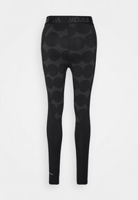 Svarta leggings med ett mönster av stora, överlappande cirklar, med en märkesmidja och ett glatt, elastiskt tyg.