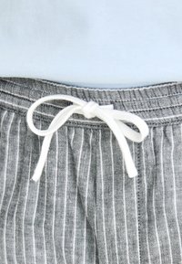 Gray and white striped shorts with a soft fabric, featuring an elastic waistband and a white drawstring tied at the center.