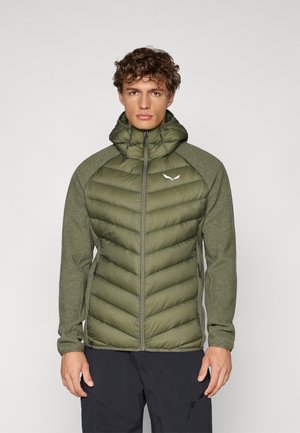 Groene gewatteerde jas met een hoge kraag, gequiltde textuur en gebreide mouwen. Ritssluiting en logodetail op de borst.