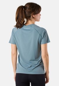 Lichtblauwe sport t-shirt met korte mouwen, gemaakt van ademend materiaal met een subtiel textuurpatroon en een logo op de achterkant.