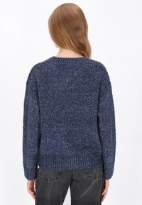 Marineblauw gebreid sweater met een gestructureerde afwerking, ronde halslijn en ribbelboorden aan de mouwen en onderkant. Eenvoudige, ontspannen pasvorm met een lichte drop shoulder.
