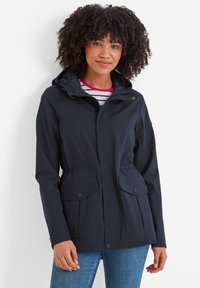 Navy blue waterproof jacket with a hood, two front pockets, elastic waist, and a zip closure. Smooth texture with a casual design.