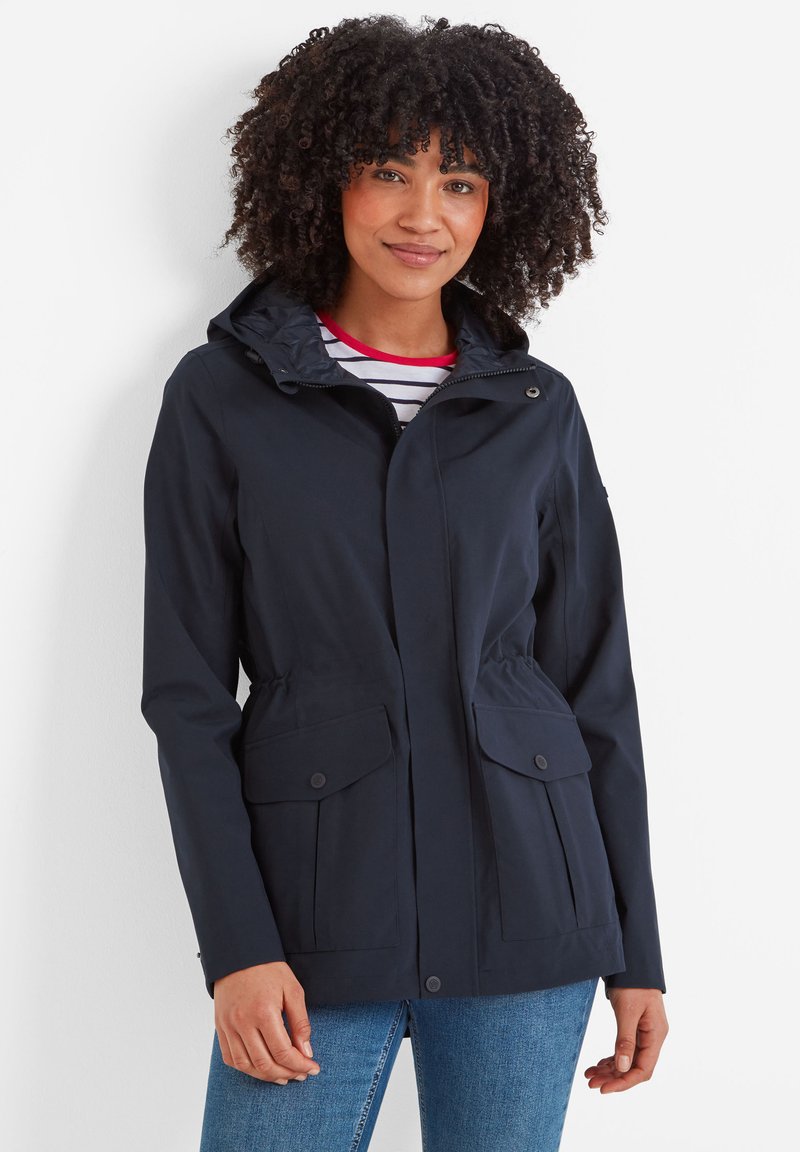 Navy blue waterproof jacket with a hood, two front pockets, elastic waist, and a zip closure. Smooth texture with a casual design.