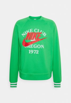 Zelená mikina s kulatým výstřihem, zdobená grafickým motivem "Nike Club Oregon 1972" v červené a bílé barvě. Pruhované akcenty na manžetách, měkká tkanina, uvolněný střih.