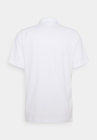 Vit polo med klassisk krage, korta ärmar, slät yta och utan synliga mönster eller dekorationer.