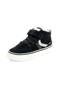 Zapatilla alta de ante negra con suela de goma blanca, que presenta cordones, una correa de Velcro y acentos beige en contraste.