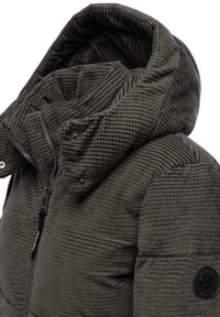 Giubbotto imbottito grigio scuro con superficie texturizzata, colletto alto, grande cappuccio e chiusura con zip. Presenta bottoni a pressione e un logo sulla manica.
