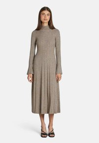 Abito a maniche lunghe in maglia a coste di colore marrone, con collo alla coreana e polsini svasati. Il design presenta una silhouette fluida di lunghezza media.