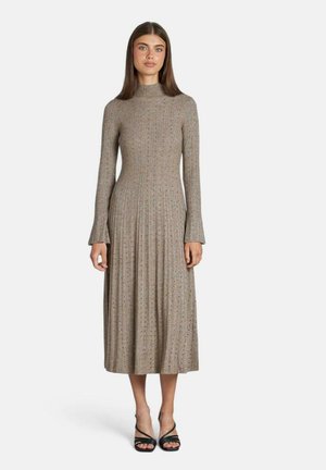 Robe en maille côtelée à manches longues, marron, avec un col montant et des poignets évasés. Le design met en avant une silhouette fluide, de longueur mi-mollet.