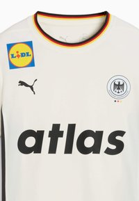 Maglietta bianca a maniche corte con colletto rotondo, logo nero e testo grafico "atlas". Presenta un colletto a righe gialle, rosse e nere e loghi degli sponsor.