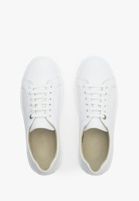 Białe sneakersy z gładką skórzaną cholewką, okrągłym noskiem, płaskim sznurowanym designem, wyściełanym kołnierzem i subtelnym logotypem na języku.