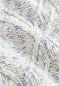Tissu tricoté multicolore avec une texture douce, présentant des motifs entrelacés dans des tons pastel de bleu, rose et crème.