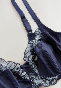 Sutien bleumarin cu un design floral argintiu brodat, țesătură netedă, margine din dantelă cu volane și bretele ajustabile cu accente din aur.
