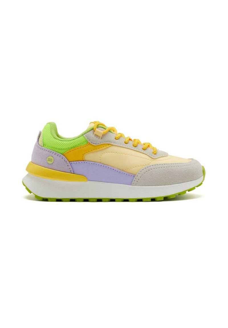 Zapatillas deportivas con una mezcla de materiales que incluyen ante y malla; los colores incluyen amarillo, verde, púrpura y beige. Suela blanca gruesa con acentos verdes.
