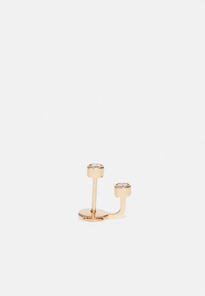 Guldtonede dobbelte stud øreringe med to klare krystaller. Slankt, minimalistisk design med en cirkulær bund og lige stænger.