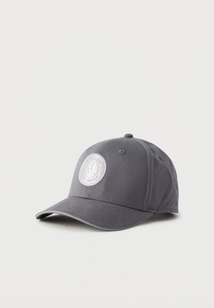 Grå baseballkasket lavet af stof med en rund, broderet sølvfarvet logo. Kasketkanten er let buet med en tekstureret finish.