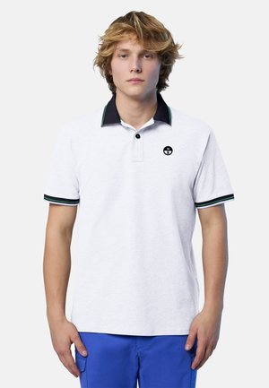 Polo bianca con colletto blu navy e dettagli verdi, presenta un logo nero sul petto e maniche corte con strisce a contrasto.