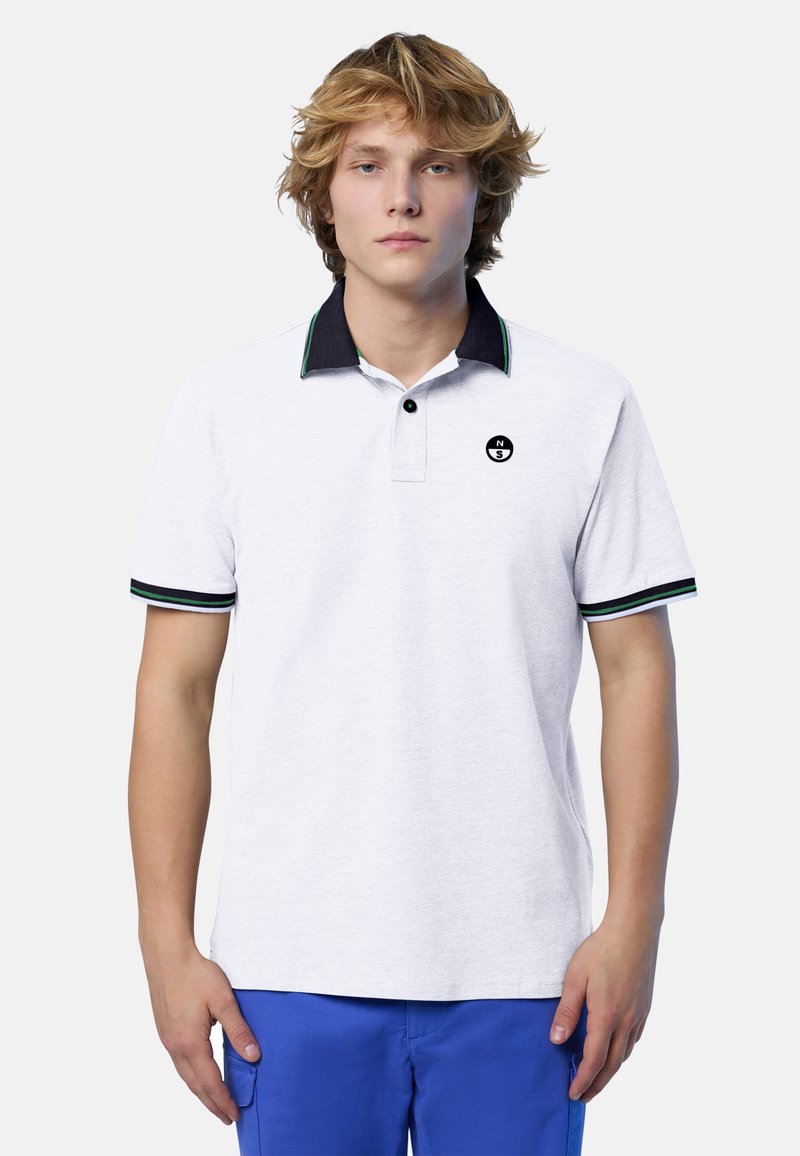 Polo bianca con colletto blu navy e dettagli verdi, presenta un logo nero sul petto e maniche corte con strisce a contrasto.