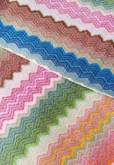 Υφασμα με πολύχρωμο ζιγκ-ζαγκ σχέδιο και υφή με λούπες σε αποχρώσεις μπλε, ροζ, πράσινο, κίτρινο και καφέ που επικαλύπτονται διαγώνια.