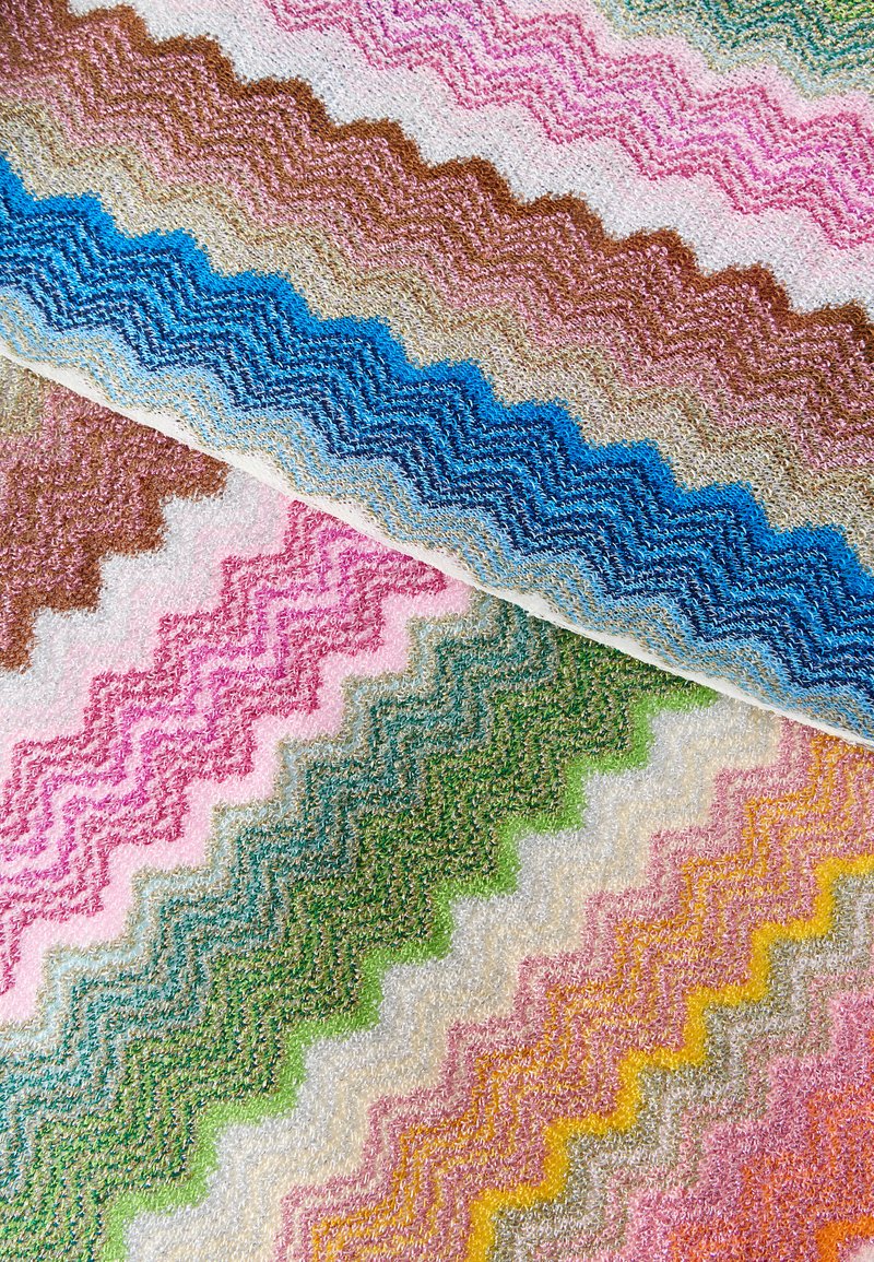 Tissu à motif zigzag multicolore avec une surface texturée en boucles dans des tons de bleu, rose, vert, jaune et marron se chevauchant en diagonale.