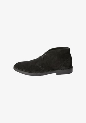 Bottine en suède noir avec deux œillets pour lacets, détails cousus et semelle basse plate.
