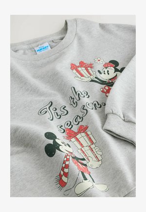 Pelēks džemperis ar apaļu kakla izgriezumu, kura priekšpusē ir apdrukāts dizains ar Mikiju un Miniju, kas tur dāvanas, un zem tā ir teksts "Iestājas sezona."