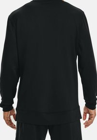 Schwarzer Langarm-Sweatshirt mit lockerer Passform, ausgestattet mit gerippten Bündchen und Saum, glatter Textur und flachen Nähten.