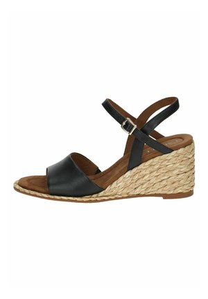 Sandale compensée en cuir noir avec des brides croisées, talon en jute, bout ouvert et détail de boucle sur la bride de cheville. Semelle intérieure brune.